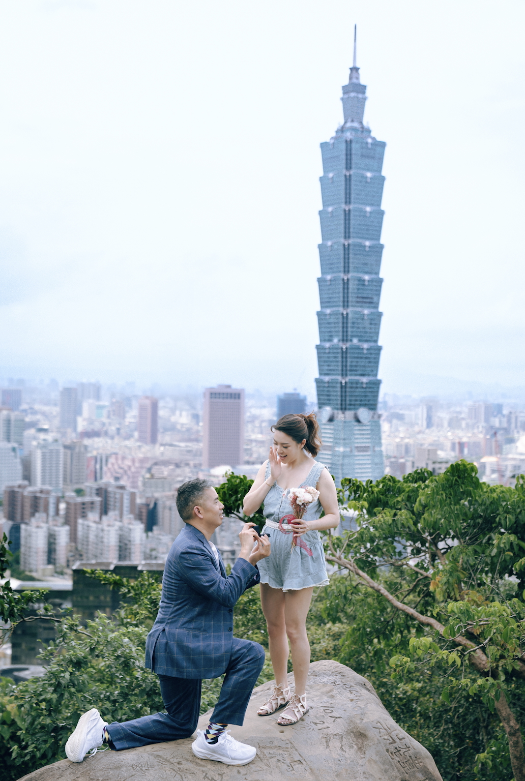 Max proposing to Margaret with Taipei 101 and city skyline in background