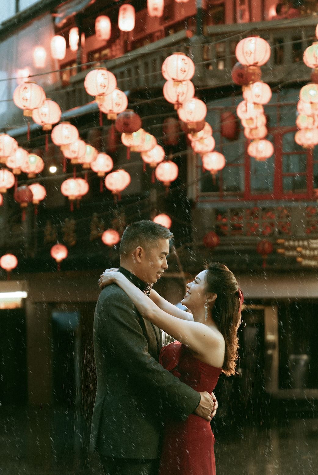 Max and Margaret dancing in the rain under beautiful red Chinese lanterns